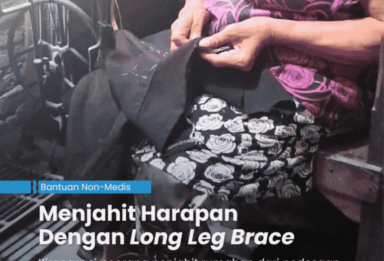 Penjahit perempuan yang sudah tua sedang duduk di kursi yang berada di depan mesih jahit manual sambil memegang celana untuk dijahit